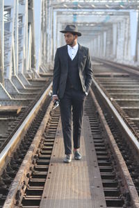Full length of young man standing on railroad tracks