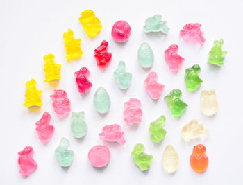 High angle view of multi colored candies against white background