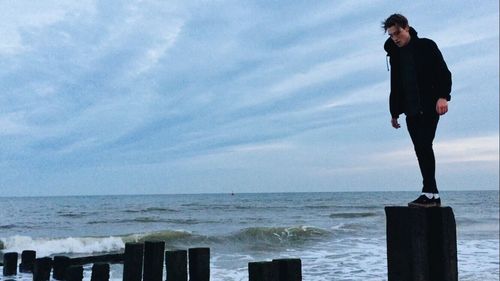 Man standing on beach against sky