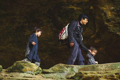 Portrait of a father leading his children on a hike through gorge