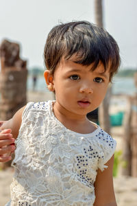 Cute girl looking away while standing at beach