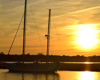 Boat sailing in sea at sunset