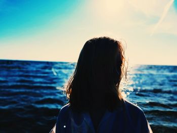 Rear view of woman standing against sea