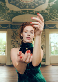 Portrait of young woman standing against ceiling