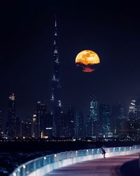 Modern buildings against sky at night