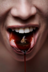 Cropped image of woman with dead bee in mouth