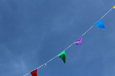 Low angle view of buntings hanging against sky