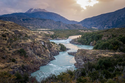 Scenic view of river amidst mountains against sky