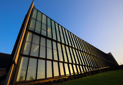 Low angle view of modern building against clear blue sky