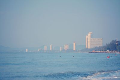 Sea and buildings against clear sky