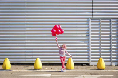 Rear view of a girl holding balloons