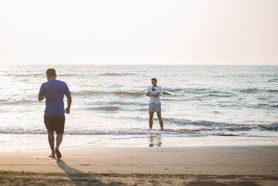 Rear view of woman walking at beach