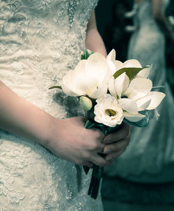 Close-up of cropped hand holding white flower