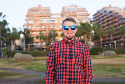 Portrait of young man wearing sunglasses standing outdoors