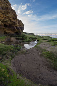 Rock formations by sea against sky