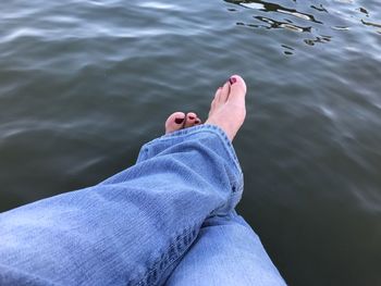 Low section of woman relaxing over lake