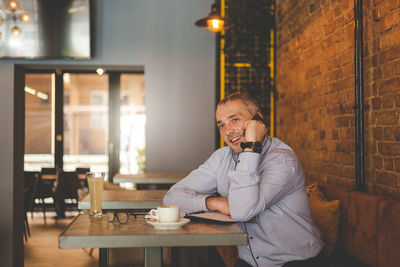 Portrait of man with coffee at table