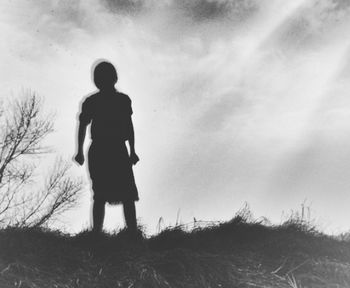 Silhouette of woman standing on field