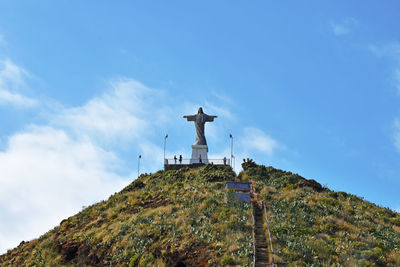 Low angle view of cross on building against sky