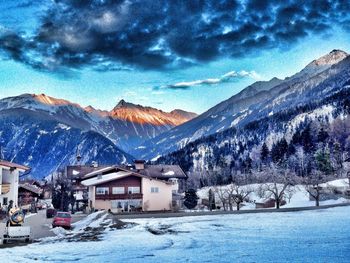 Scenic view of snow covered mountains against cloudy sky