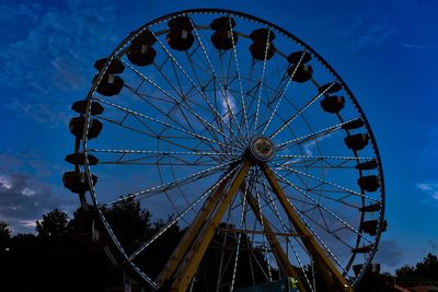 Low angle view of ferris wheel against blue sky