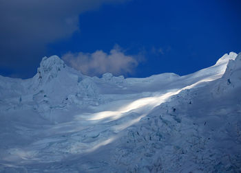 Scenic view of mountain range against cloudy sky