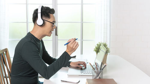 Side view of young woman using mobile phone