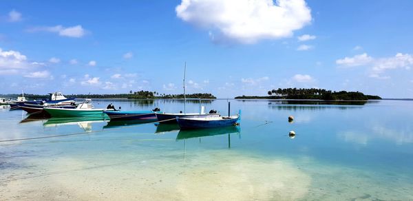 Boats moored in sea against sky