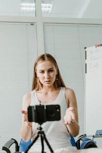 Young woman teaching students over video call