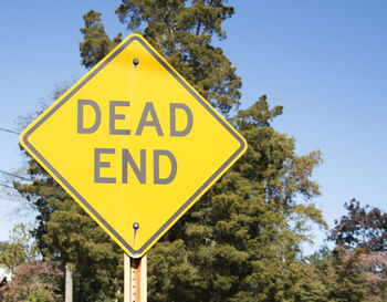 Close-up of road sign against clear sky