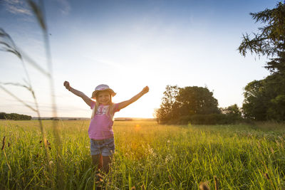 Full length of smiling girl on field against sky