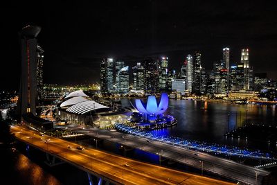 High angle view of illuminated buildings by river at night