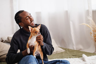 Portrait of young woman with dog at home