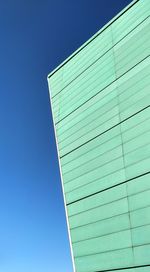 Low angle view of modern building against clear blue sky