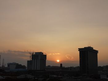 Silhouette buildings against sky during sunset