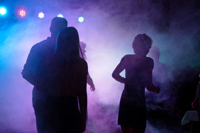 People amidst smoke in party at night