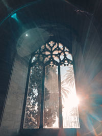 Low angle view of sunlight streaming through glass window