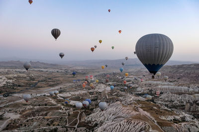 Hot air balloons flying over landscape