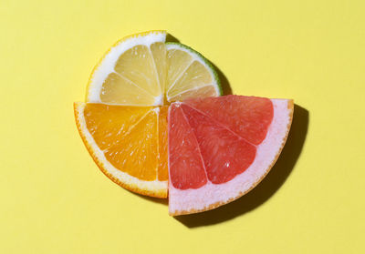 Close-up of lemon slice in plate against orange background