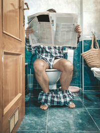 Low section of man sitting in bathroom