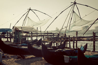 Boats moored at harbor against clear sky