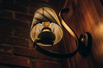 Close-up of illuminated electric lamp against wall