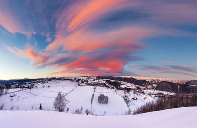 Snow covered landscape against sky