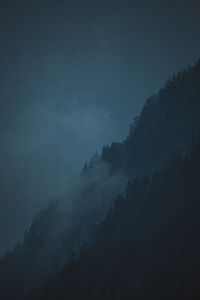 Scenic view of mountains against dark sky