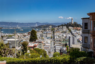 Aerial view of city by sea against sky