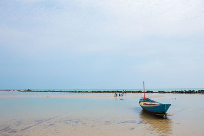 Boat moored on sea against sky