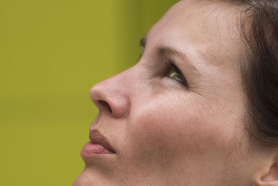 Close-up of young woman over yellow background