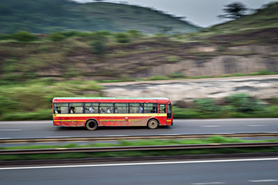 Bus moving on road against mountain