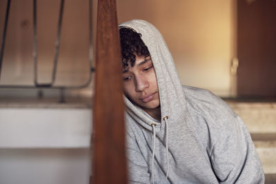 Boy sitting on stairs and leaning against railing