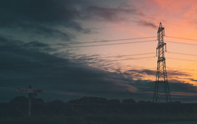 Silhouette electricity pylon on field against sky during sunset